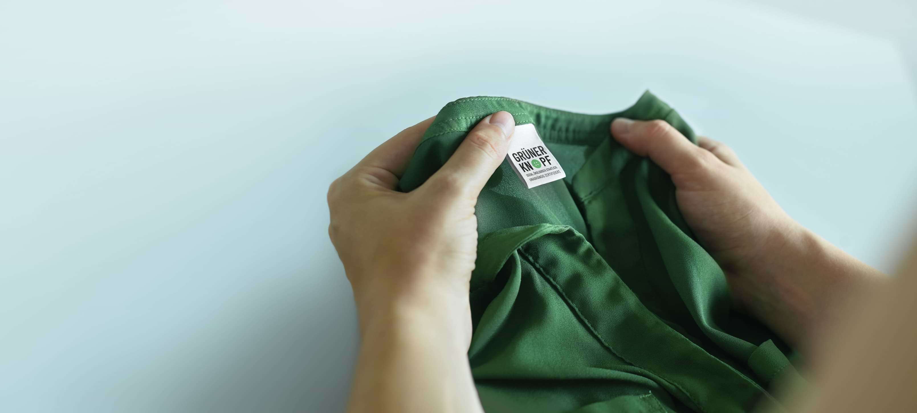 Eine Person liest das Etikett in einem Kleidungsstück